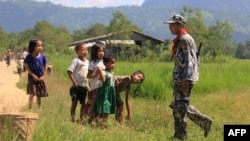 រូបឯកសារ៖ កុមារជនជាតិភាគតិច Myo សម្លឹងមើលយោធាព្រំដែនមីយ៉ាន់ម៉ា នៅក្នុងភូមិ LaungDon ក្នុងរដ្ឋ Rakhine ប្រទេសមីយ៉ាន់ម៉ា កាលពីថ្ងៃទី៩ ខែតុលា ឆ្នាំ២០១៦។