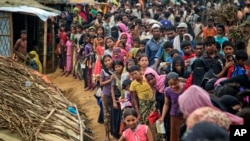 Rohingya Muslims, who from Myanmar into Bangladesh, wait in queues to receive aid at Kutupalong refugee camp in Ukhiya, Bangladesh, Nov. 15, 2017.