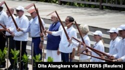 Dari kiri, Kanselir Jerman Olaf Scholz, Perdana Menteri Australia Anthony Albanese, Presiden AS Joe Biden, Perdana Menteri India Narendra Modi, Presiden Joko Widodo, Presiden Komisi Eropa Ursula von der Leyen, dan sejumlah pemimpin negara G20 saat menanam bakau di Bali. 