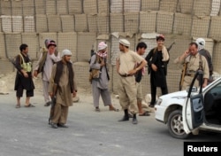FILE - Members of the Afghan Local Police (ALP) keep watch at a checkpoint at Chardara district, in Kunduz province, Afghanistan, June 23, 2015.