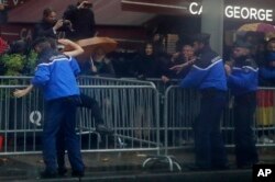 French police officers apprehend a topless protestor who ran toward the motorcade of President Donald Trump who was headed on the Champs Elysees to an Armistice Day Centennial Commemoration at the Arc de Triomphe, Nov. 11, 2018, in Paris.