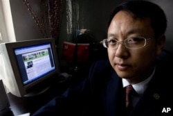 中国律师刘晓原在他的办公室里，旁边的电脑显示他的文章（2007年10月12日）