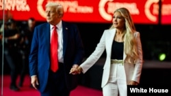 唐纳德·特朗普总统与埃丽卡·科克一同登上亚利桑那州格伦代尔州立农业体育场举行的查理·科克追悼会讲台。(白宫照片，2025年9月21日)