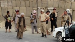 FILE - Afghan Local Police (ALP) keep watch at a checkpoint at Chardara district, in Kunduz province, Afghanistan, June 23, 2015. 