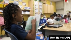 A third-grade student reads to her class at Beecher Hills Elementary School on Friday, Aug. 19, 2022, in Atlanta. (AP Photo/Ron Harris)
