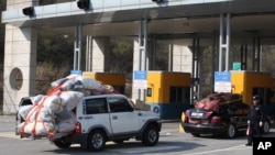 2013年4月27日开城工业园的韩国人员装满物品，由轿车和卡车组成车队跨境返回韩国。