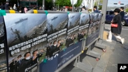 FILE: Posters showing South Korea's president-elect Yoon Suk Yeol are displayed to denounce his North Korea policy on a street in Seoul, South Korea, April 27, 2022.