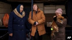 People fleeing the village of Ruska Lozova wait at a screening point in Kharkiv, Ukraine, April 29, 2022.