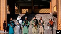 Pejuang Taliban berjaga di sebuah masjid pada hari pertama Idulfitri di Kabul, Afghanistan, Minggu, 1 Mei 2022. (Foto: AP)