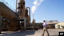 FILE - Derek Benson, chief operating officer of EnergySource Minerals, walks through the Featherstone plant in Calipatria, Calif., where the company is producing geothermal energy and extracting lithium from brine, July 16, 2021.
