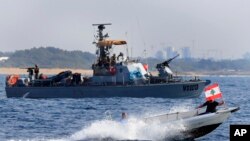 Sejumlah warga Lebanon menggelar aksi protes dengan membawa bendera negara mereka ketika berlayar di depan kapal angkatan Laut Israel di wilayah maritim di Kota Naqoura, Lebanon, pada 4 September 2022. (Foto: AP/Mohammed Zaatari)