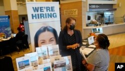 FILE - Marriott human resources recruiter Mariela Cuevas, left, talks to Lisbet Oliveros, during a job fair in Florida, Sept. 3, 2021.