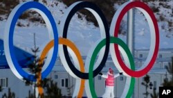 A person stands in the Olympic Rings during a cross-country skiing training session before the 2022 Winter Olympics, Feb. 3, 2022, in Zhangjiakou, China. 