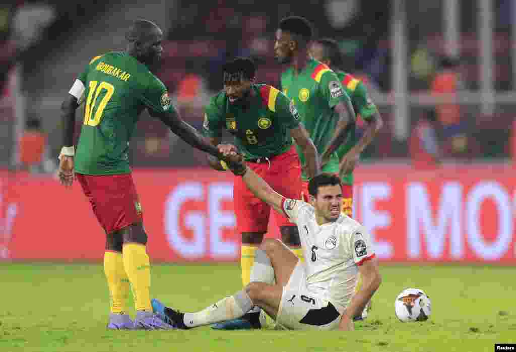 Cameroon&#39;s Andre-Frank Zambo Anguissa and Vincent Aboubakar help Egypt&#39;s Hamdi Fathi, Feb. 3, 2022.