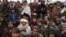 FILE - Hundreds of Afghan men gather to apply for humanitarian aid, in Qala-e-Naw, Afghanistan, Dec. 14, 2021.