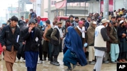 Afghans wait for food rations from the World Food Program in Pul-e-Alam, Logar province. Afghanistan, Jan. 18, 2022. The Taliban's sweep to power in August drove billions of dollars in international assistance out of the country.