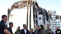 US Secretary of State Antony Blinken stands near a damaged residential building during his visit the city of Irpin, Ukraine, Sept. 8, 2022.