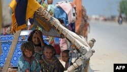 Internally displaced flood-affected children rest under makeshift shelter along a road in higher ground in flooded area after heavy monsoon rains on the outskirts of Jacobabad, Sindh province, Sept. 6, 2022.