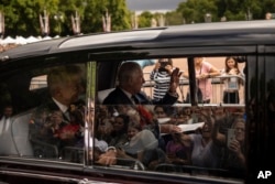 King Charles III greets supporters as he arrives at Buckingham Palace in London, Sept. 10, 2022.