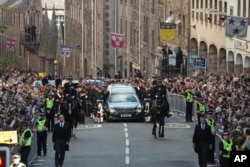 The procession with the coffin of Queen Elizabeth II, followed by King Charles III, Princess Anne and Prince Andrew, heads up the Royal Mile to St Giles' Cathedral in Edinburgh, Monday, Sept. 12, 2022.
