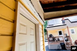 Harold Lewis, seorang pengguna narkoba yang baru pulih, berbicara dengan pacarnya di teras rumah ibunya, Selasa, 19 Juli 2022 di Stratford, Conn. (AP/Julia Nikhinson)