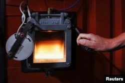 The furnace of a biomass generator is seen through a window at a greenhouse in Grubbenvorst, Netherlands September 5, 2022. REUTERS/Piroschka van de Wouw