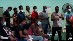 FILE - Migrants who crossed the U.S.-Mexico border illegally and turned themselves in receive assistance at a respite center, in Del Rio, Texas, June 16, 2021.