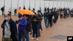Residents line up to get tested for the coronavirus at a temporary testing center for COVID-19 in Hong Kong Monday, Feb. 7, 2022. (AP Photo/Vincent Yu)