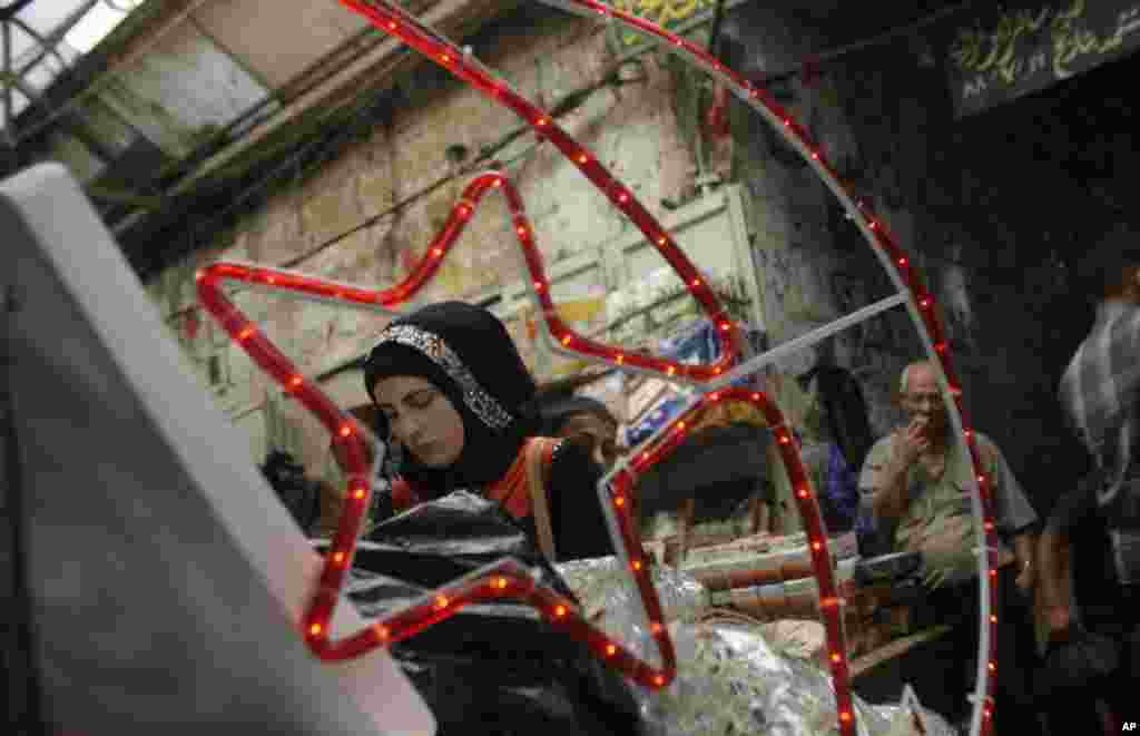 Seorang perempuan Palestina membeli dekorasi tradisional Ramadan di sebuah pasar di kota Tepi Barat di Nablus (9/7). (AP Photo / Nasser Ishtayeh) 