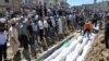 People gather at a mass burial for the victims purportedly killed during an artillery barrage from Syrian forces in Houla in this handout image provided by Shaam News Network, May 26, 2012.