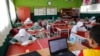 Siswa sekolah dasar mengenakan masker dan duduk sesuai aturan untuk menjaga jarak sosial, kembali belajar di kelas mereka, saat sekolah dibuka kembali di tengah pandemi COVID-19 di Bekasi, 24 Maret 2021. (REUTERS / Willy Kurniawan)
