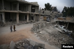 FILE - Children walk near rubble of damaged buildings in the rebel-held besieged city of Douma, in the eastern Damascus suburb of Ghouta, Syria, Nov. 13, 2016.