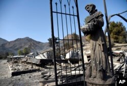 A religious statue stands amongst destroyed properties in the Seminole Springs Mobile Home Park, Nov. 11, 2018, after wildfires tore through the neighborhood in Agoura Hills, California.