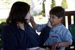 Fatima Bakhshi, a migrant from Afghanistan, left, talks to her five-year-old son Ahmed, in a small care home in the village of Doljevac, in southern Serbia, April 10, 2017.
