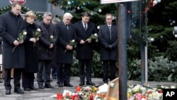From left, the Mayor of Berlin Michael Mueller, German Chancellor Angela Merkel, German Interior Minister Thomas de Maiziere and German Foreign Minister Frank-Walter Steinmeier attend a flower ceremony at the Kaiser-Wilhelm Memorial Church in Berlin.