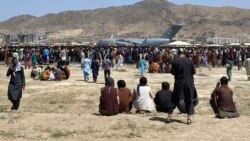 In this Aug. 16, 2021, file photo hundreds of people gather near a U.S. Air Force C-17 transport plane along the perimeter at the international airport in Kabul, Afghanistan. (AP Photo/Shekib Rahmani, File)