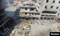 Residents inspect a damaged site after airstrikes on a market in the rebel controlled city of Idlib, Syria, Sept. 10, 2016.