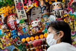 Seorang pembeli menunggu di toko suvenir di Olympic Pres Center Olimpiade Musim Panas 2020 di Tokyo, Jepang, Kamis, 22 Juli 2021. (Foto AP/John Minchillo)