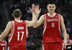 Houston Rockets Yao Ming (11) high fives teammate Brent Barry (17) during the fourth quarter of their NBA basketball game against the Cleveland Cavaliers in Ohio, Dec. 23, 2008 (Reuters).