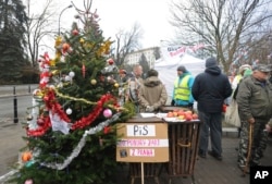 Protesters supporting opposition lawmakers stand next to a Christmas tree in front of the parliament in Warsaw, Poland, Dec. 23, 2016. Opposition lawmakers are hunkered down for sit-in occupation of parliament to protest what they consider backsliding on democracy.