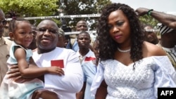 FILE - Sierra Leone’s president, Julius Maada Bio, and his wife, Fatima, leave after voting at the polling station in the final round of a delayed run-off presidential election, March 31, 2018, in Freetown.