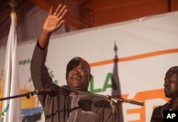FILE - Newly elected president of Burkina Faso, Roch Marc Christian Kabore, waves at supporters outside his campaign headquarters in Ouagadougou, Burkina Faso, Dec. 1, 2015