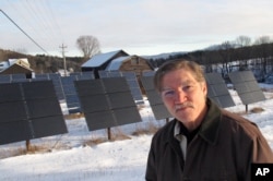 Jeff Forward stands in front of solar panels, which are part of a community array, on his property in Richmond, Vt., Jan. 22, 2016. Vermont's commitment to renewable energy has created a job-producing boom in renewable energy projects.