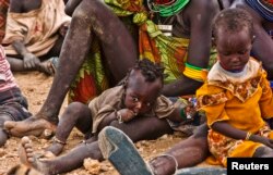 FILE - Turkana women and their children wait to receive relief food supplies near the Kakuma Refugee Camp, Turkana District, northwest of Kenya's capital Nairobi, August 8, 2011.