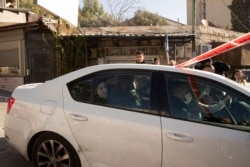 Polisi Israel menangkap seorang perempuan muda Palestina, (duduk di kursi belakang mobil), menyusul serangan penikaman di Sheikh Jarrah, Yerusalem timur, Rabu, 8 Desember 2021.