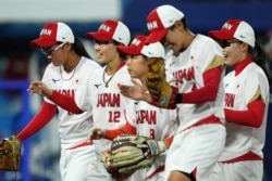 Team Japan shortstop Mana Atsumi (12) celebrates with teammates after an inning ending double play against the United States of America during the sixth inning in the gold medal game of the Tokyo 2020 Olympic Summer Games at Yokohama Baseball Stadium. (Kareem Elgazzar-USA TODAY Sports)