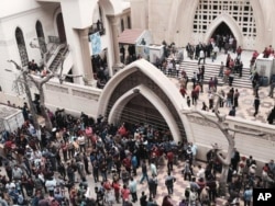 Relatives and onlookers gather outside a church after a bomb attack in the Nile Delta town of Tanta, Egypt, Sunday, April 9, 2017.
