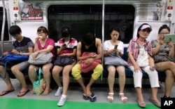 서울 지하철 운행중 이동통신을 이용하고 있는 승객들.