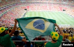 Fans hold a Brazilian flag before the Confederations Cup Group A soccer match between Brazil and Japan, June 15, 2013.