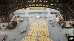 Thousands of people performed yoga on yellow mats at the Eiffel Tower in Paris Sunday.